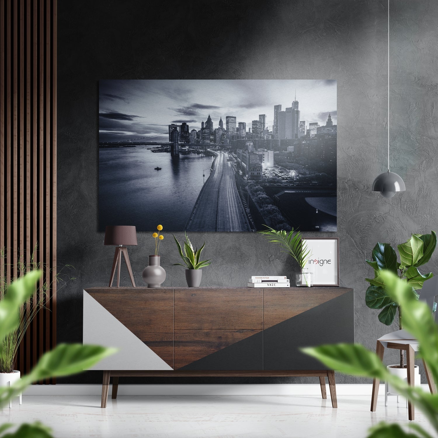 Monochrome Manhattan skyline photograph mounted on grey textured wall above wooden console table with plants and accessories.