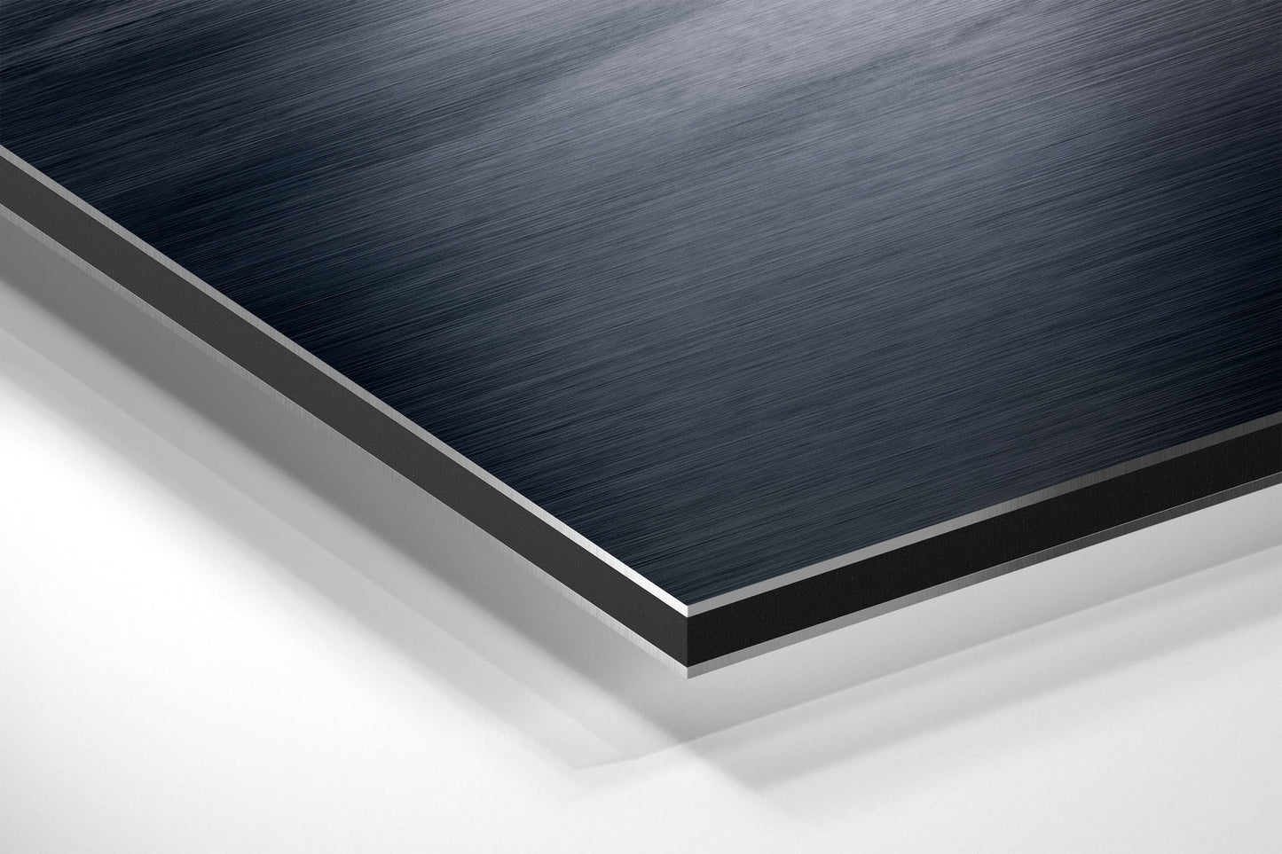 Close-up angled view of layered Dibond panel showing brushed dark blue top surface with silver and white composite layers beneath.