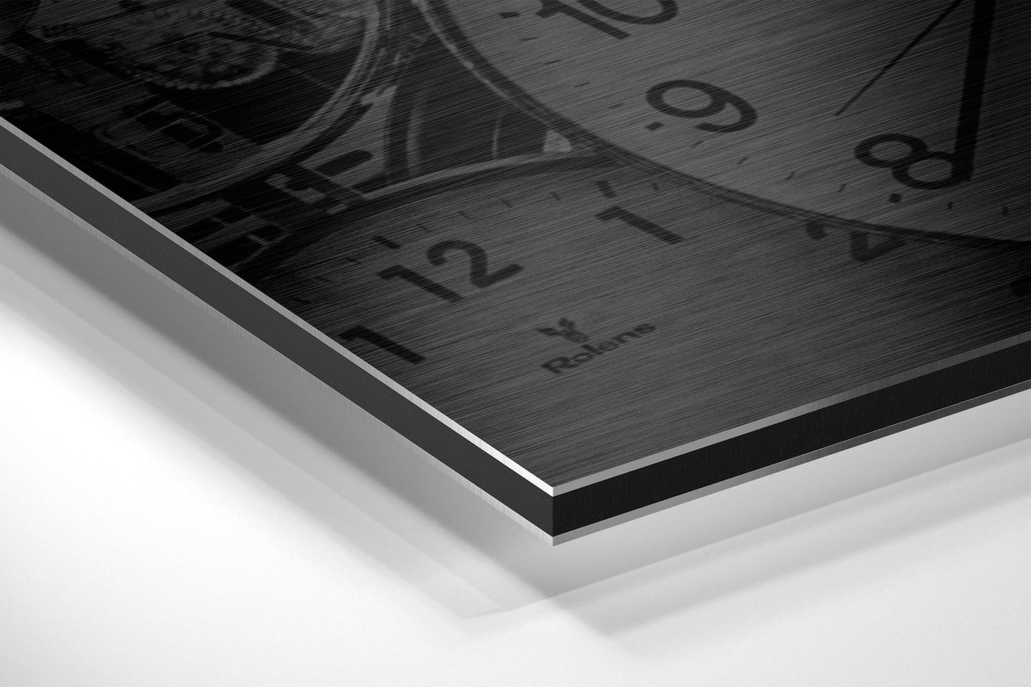 Close-up angled view of brushed aluminum Dibond wall art showing layered edge detail with black brushed surface and white backing board.