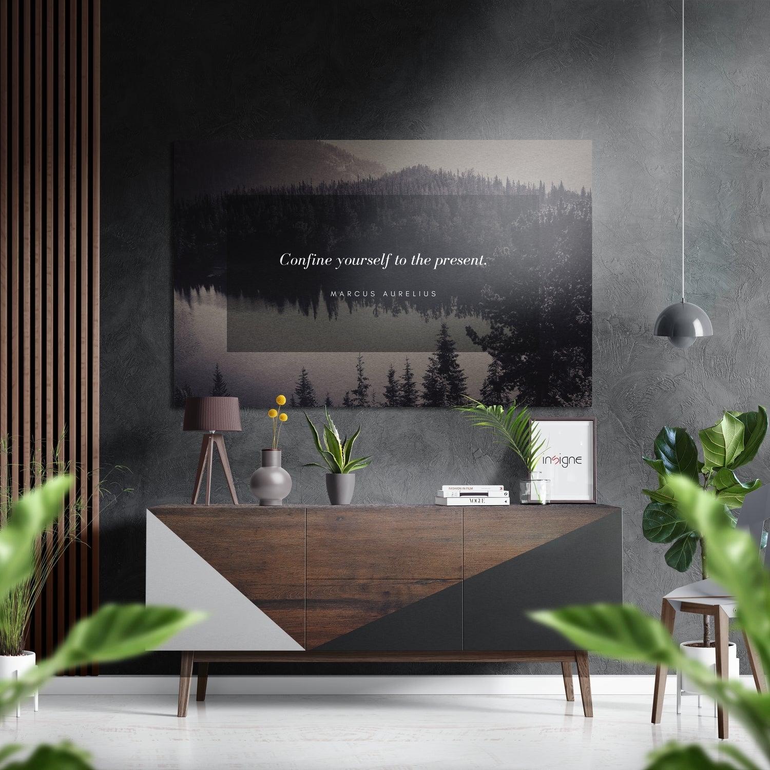 Modern interior with forest landscape wall art displaying "Confine yourself to the present" quote above wooden dresser with plants and pendant lamp.