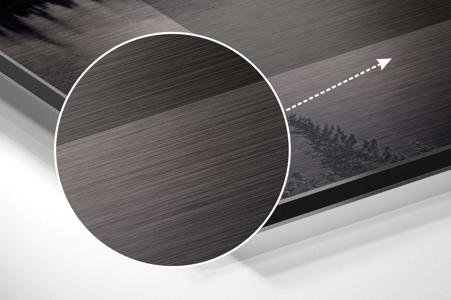 Angled perspective view of circular brushed aluminum wall art with white border and directional arrow, mounted on textured gray surface.