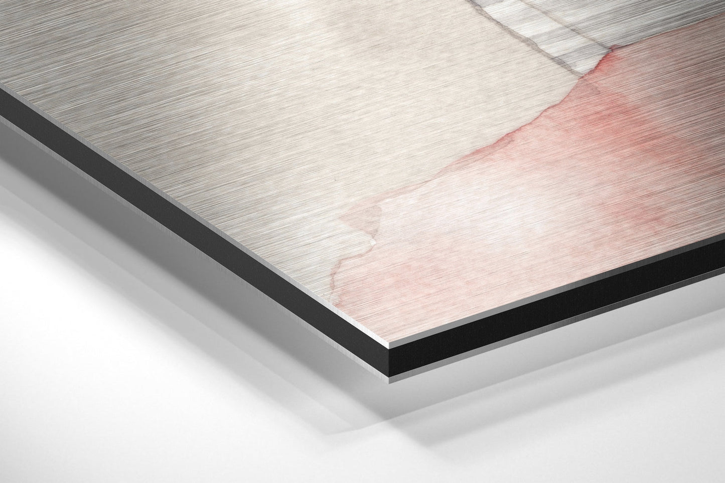 Close-up angled view of brushed aluminum Dibond panel showing layered edge with pink and white brushed metal surface detail.