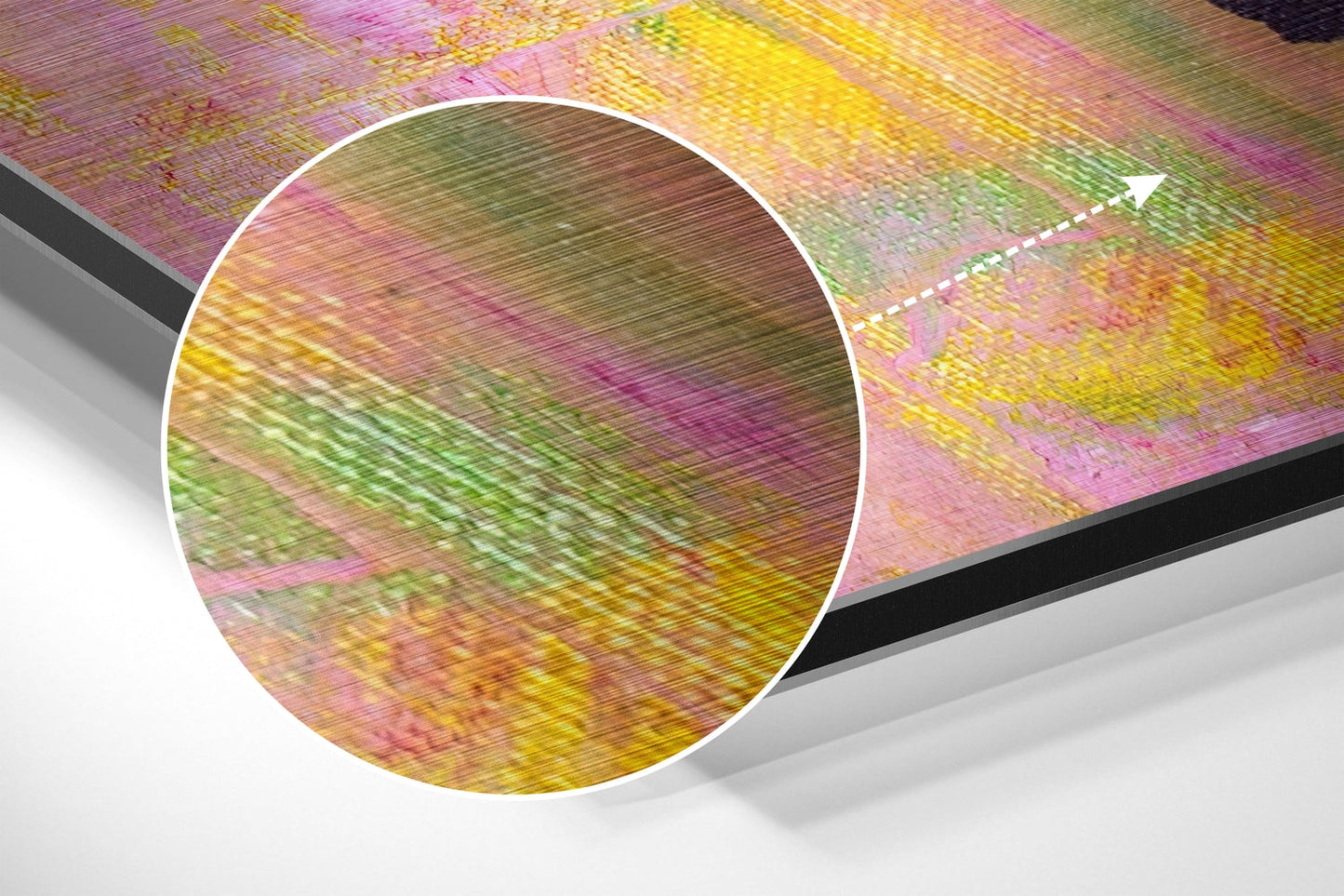 Close-up detail of brushed aluminum surface showing multicolored horizontal streaks in pink, yellow, green, and gold tones with directional arrow.