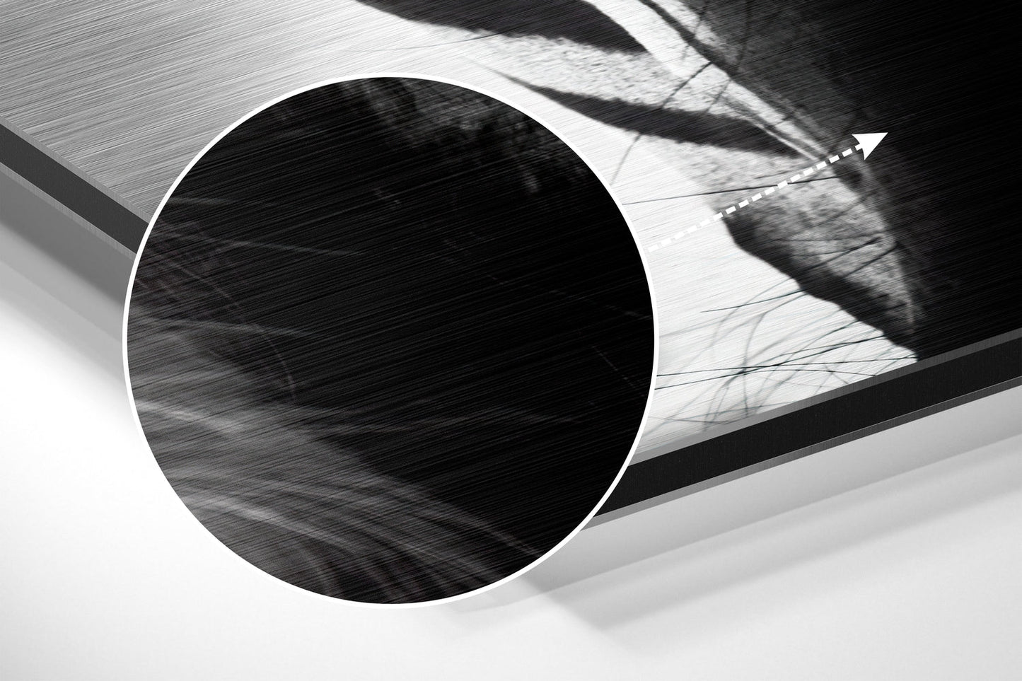 Close-up detail of brushed aluminum surface showing circular opening and textured metallic finish in black and white.