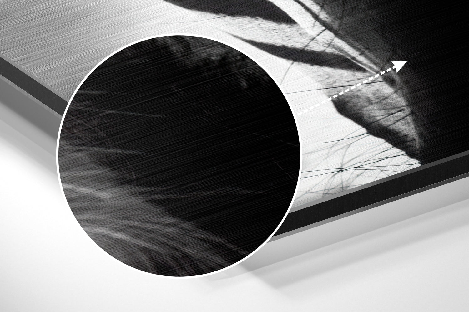 Close-up detail of brushed aluminum surface showing circular opening and textured metallic finish in black and white.