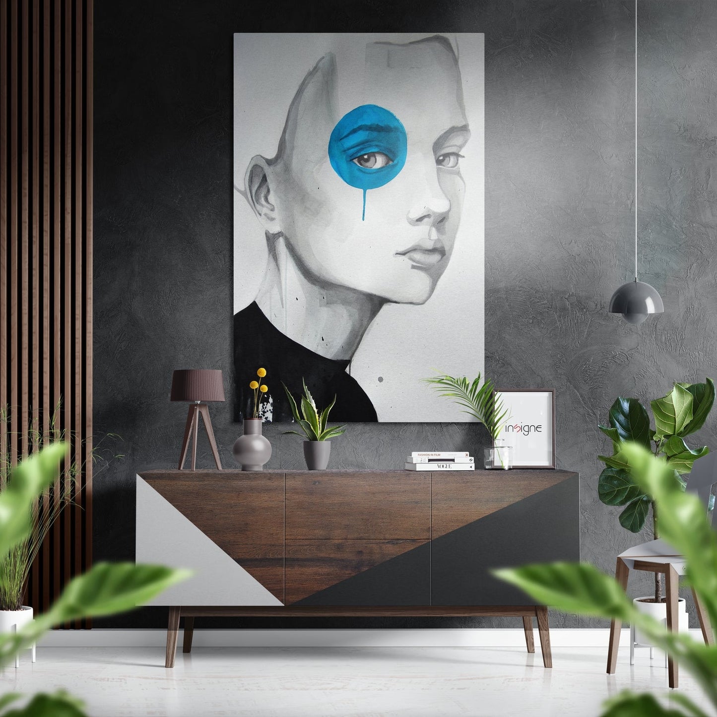 Modern interior display featuring a grayscale portrait with a blue circular eye overlay mounted above a wooden console table with plants and décor.