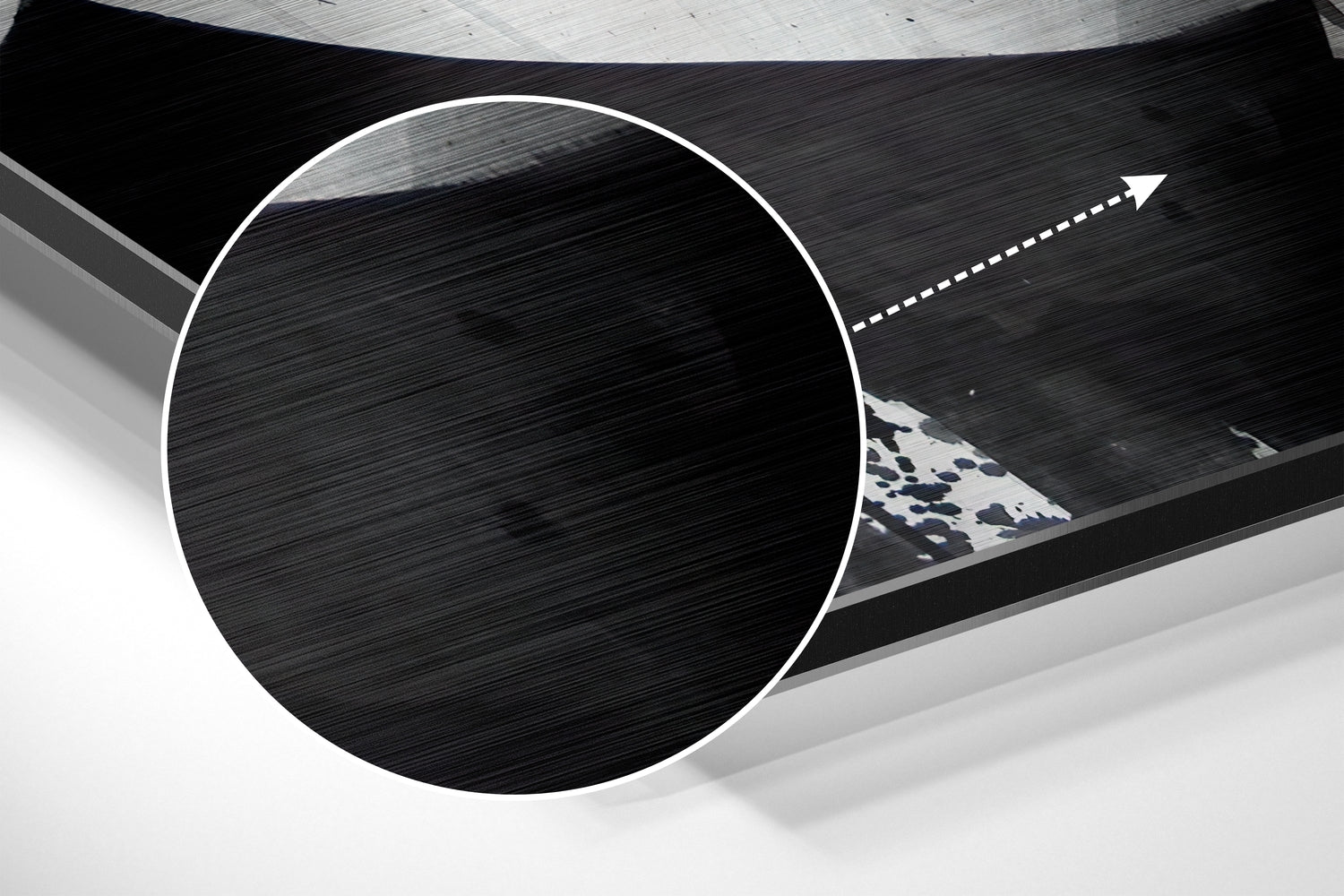 Close-up angled view of circular brushed aluminum wall art with white border and blue patterned triangular detail visible through opening.