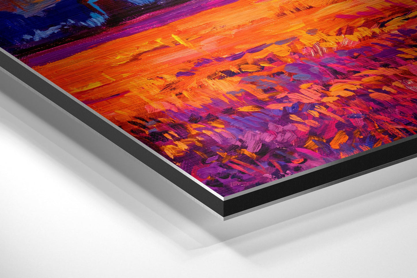 Angled close-up view of brushed aluminum dibond print showing vibrant orange, purple, and magenta abstract sunset brushstrokes with layered edge detail.