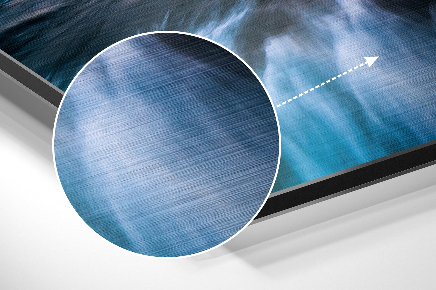 Close-up detail of brushed aluminum surface with blue ocean and sky gradients, white border circle, and directional arrow.