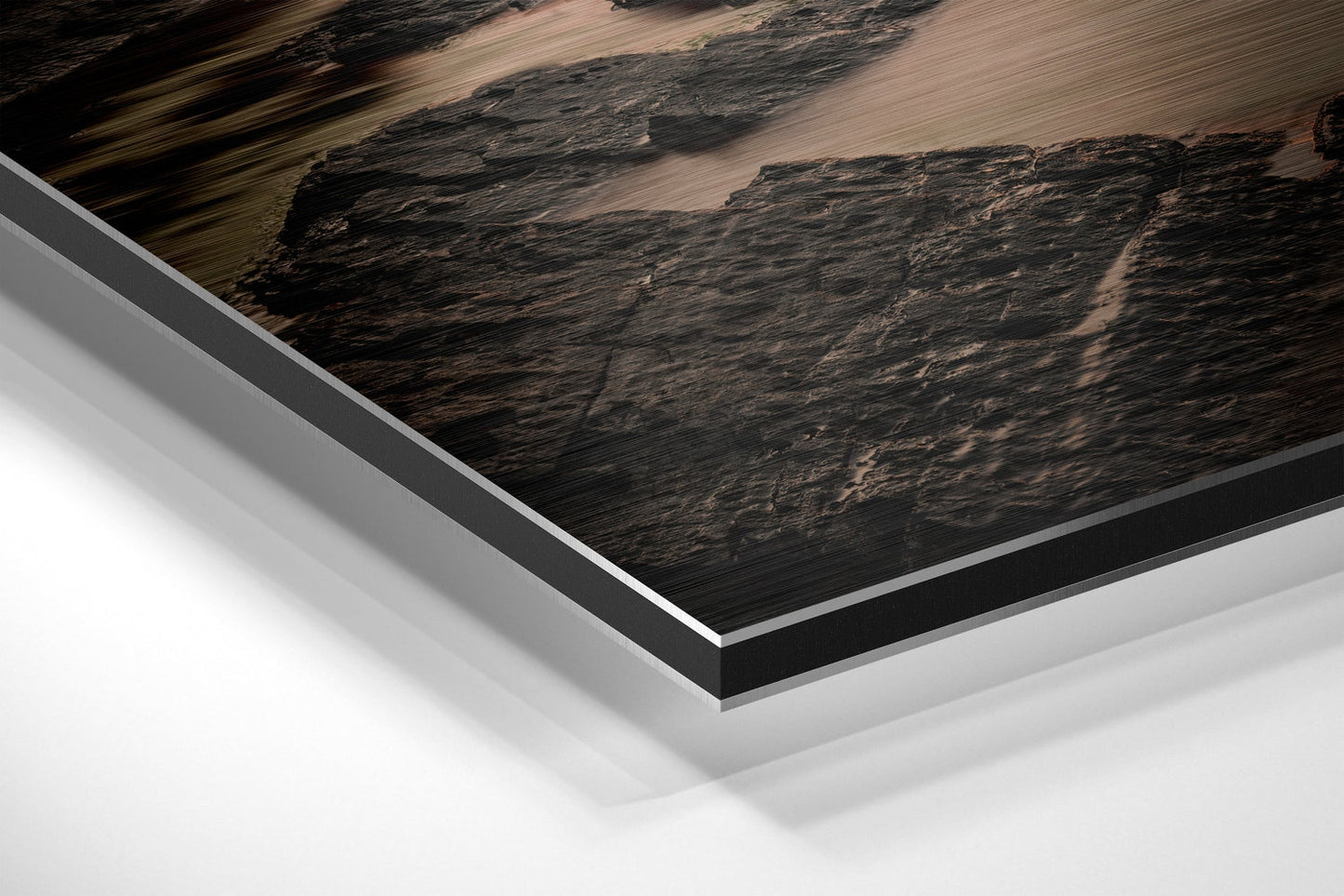 Close-up angled view of layered Dibond panel showing dark textured landscape print with white and gray aluminum backing layers.
