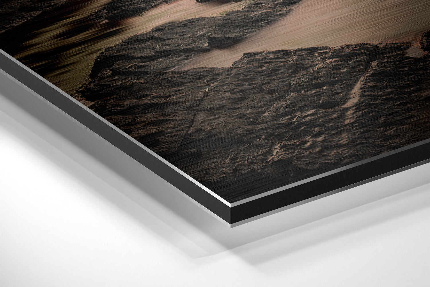 Close-up angled view of layered Dibond panel showing dark textured landscape print with white and gray aluminum backing layers.