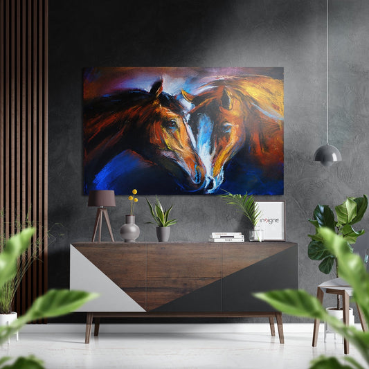 Colorful abstract horse heads painting with orange, blue, and gold tones displayed above wooden console table in modern interior setting.