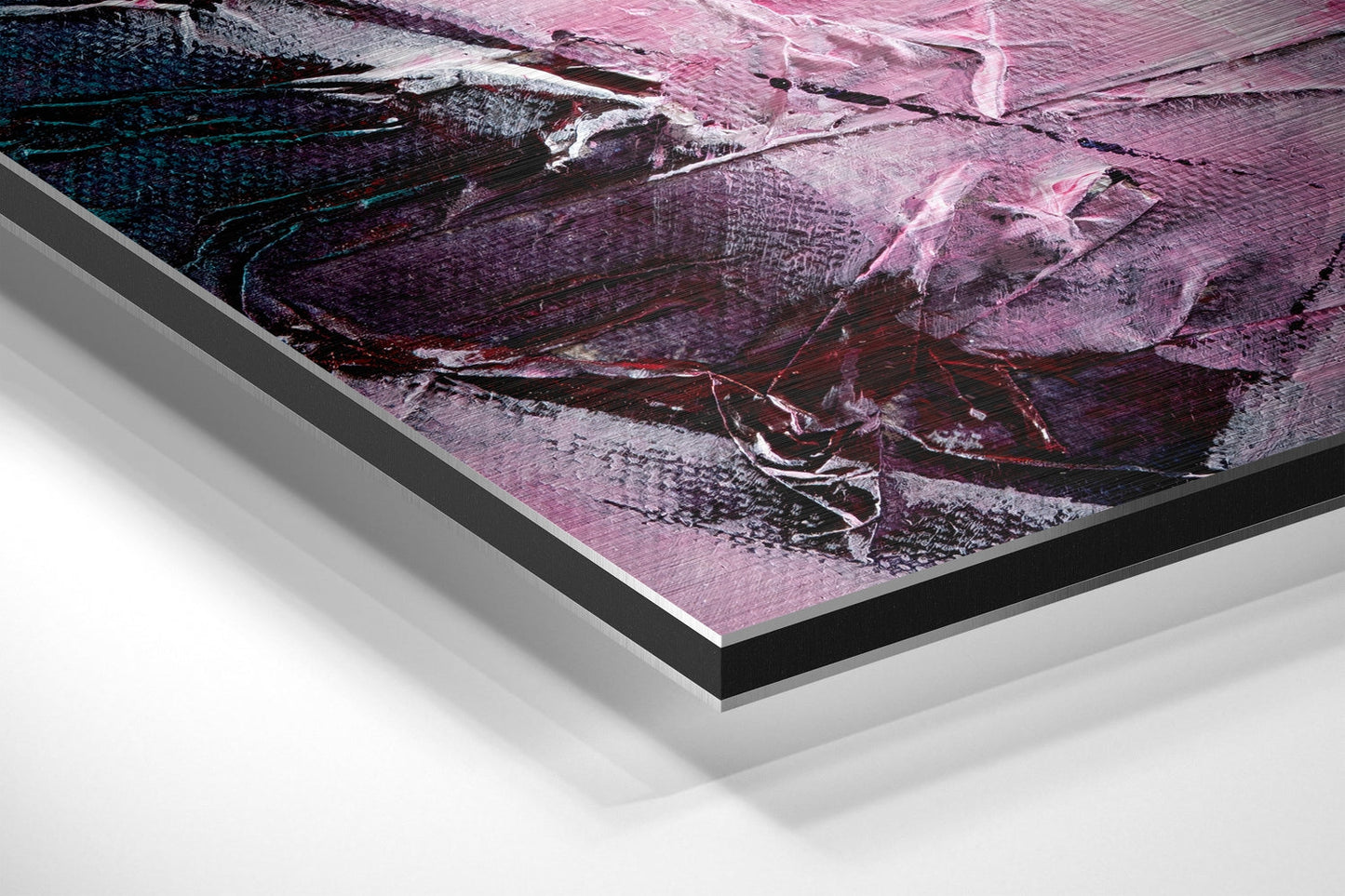 Close-up angled view of brushed aluminium Dibond wall art with pink, purple, and dark abstract brushstroke design and black edge framing.
