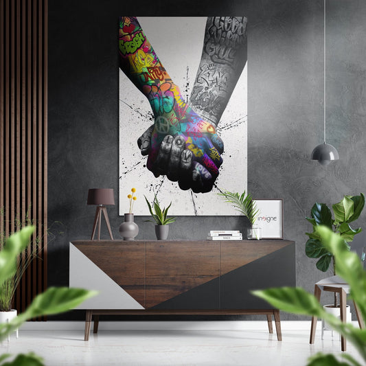 Modern interior with colorful graffiti hands artwork displayed above wooden console table with plants and decor.