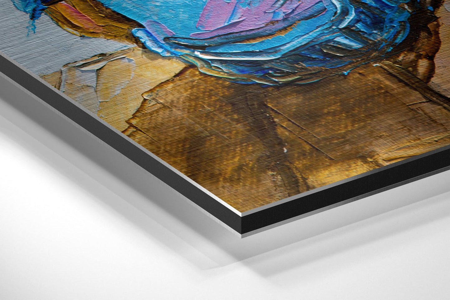 Close-up angled view of brushed aluminium Dibond wall art showing layered edge construction with blue, pink, and golden-brown painted artwork visible on top surface.