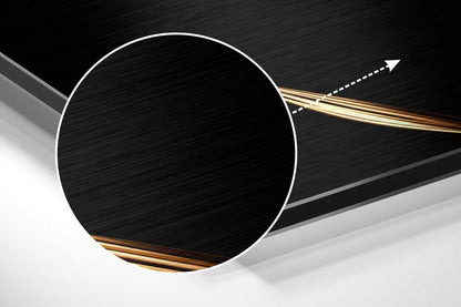 Close-up angled view of brushed aluminum dibond showing white circular edge, golden metallic accents, and directional arrow indicating installation direction.