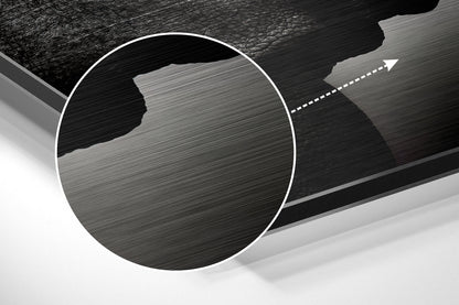 Close-up of brushed aluminium Dibond wall art showing textured metallic surface with circular white border and directional arrow detail.