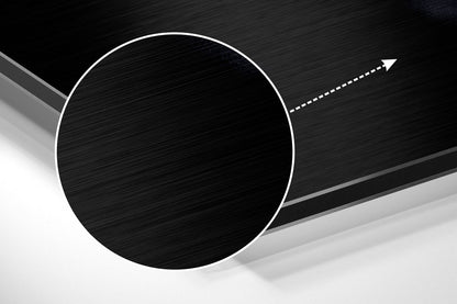 Abstract geometric composition featuring a large white-outlined black circle on brushed metal surface with directional arrow.