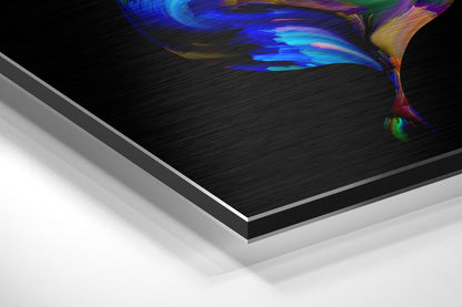Angled perspective view of layered Dibond panel showing brushed aluminum edges with colorful abstract butterfly artwork featuring blue, purple, and yellow tones on black surface.