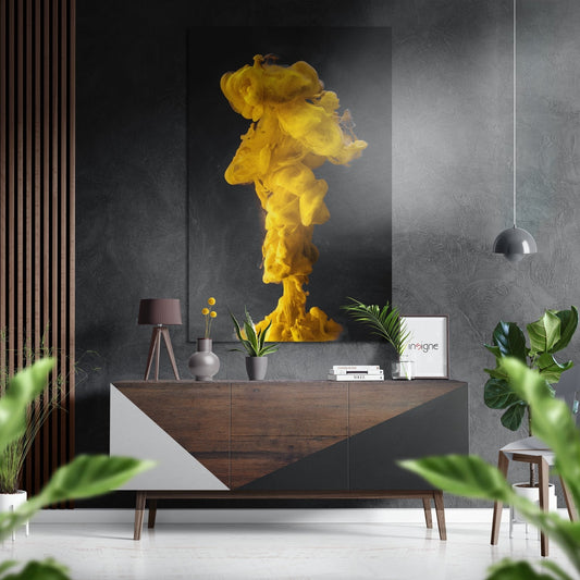 Yellow ink cloud burst column art displayed above wooden dresser in modern gray interior with plants and pendant light.