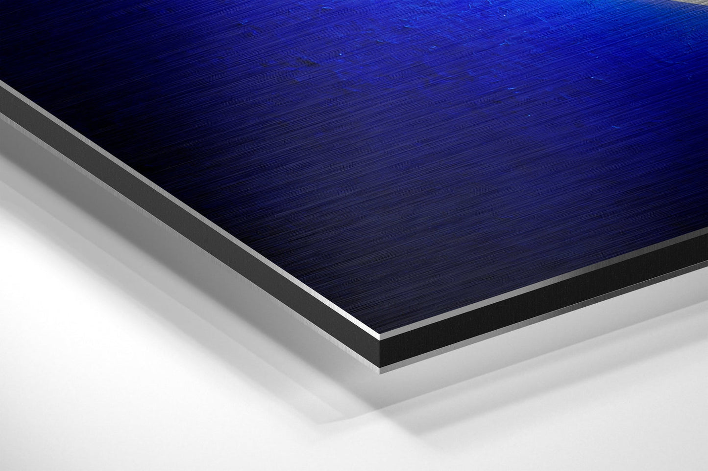 Close-up angled view of layered brushed aluminum Dibond panel with dark blue textured top surface and silver metallic edges against white background.