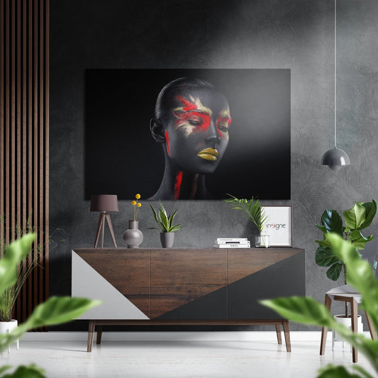 Modern interior display showing black body paint artwork with red and gold accents hung above wooden console table with accessories.