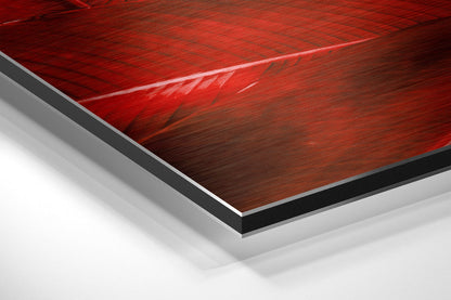 Close-up angled view of layered Dibond wall art showing red brushed aluminum surface with black and white backing layers.