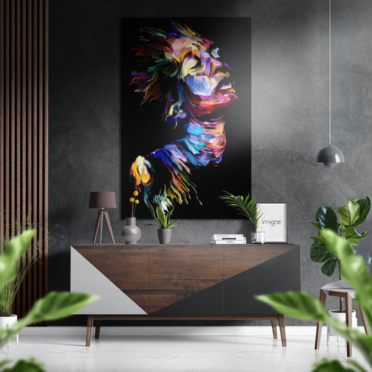 Colorful abstract portrait with vibrant brushstrokes displayed above wooden sideboard in modern interior setting.