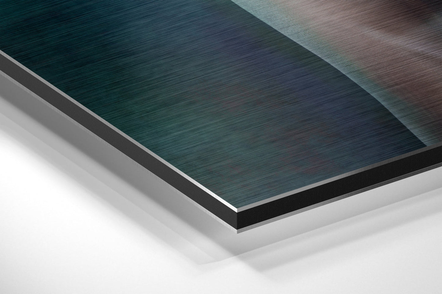 Angled overhead view of stacked Dibond sheets showing teal, gray, and white brushed aluminum layers with visible edge details.