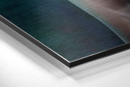 Angled overhead view of stacked Dibond sheets showing teal, gray, and white brushed aluminum layers with visible edge details.