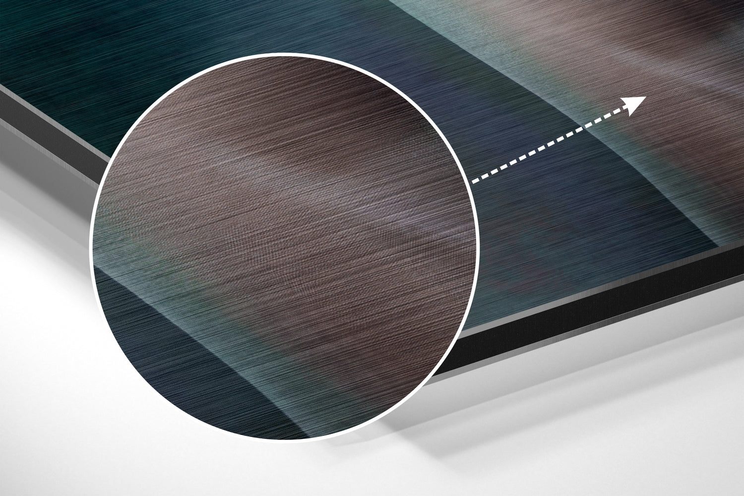 Close-up detail of brushed aluminium surface showing brown and teal wood-grain texture with white circular border and directional arrow.