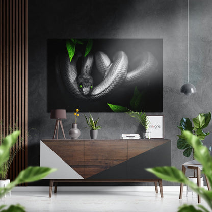 Black and white snake with glowing green eyes and green leaves, displayed above wooden dresser in modern interior setting.