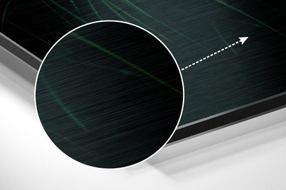 Close-up angled view of brushed aluminum wall art showing dark teal circular panel with white border and directional arrow against layered gray background.