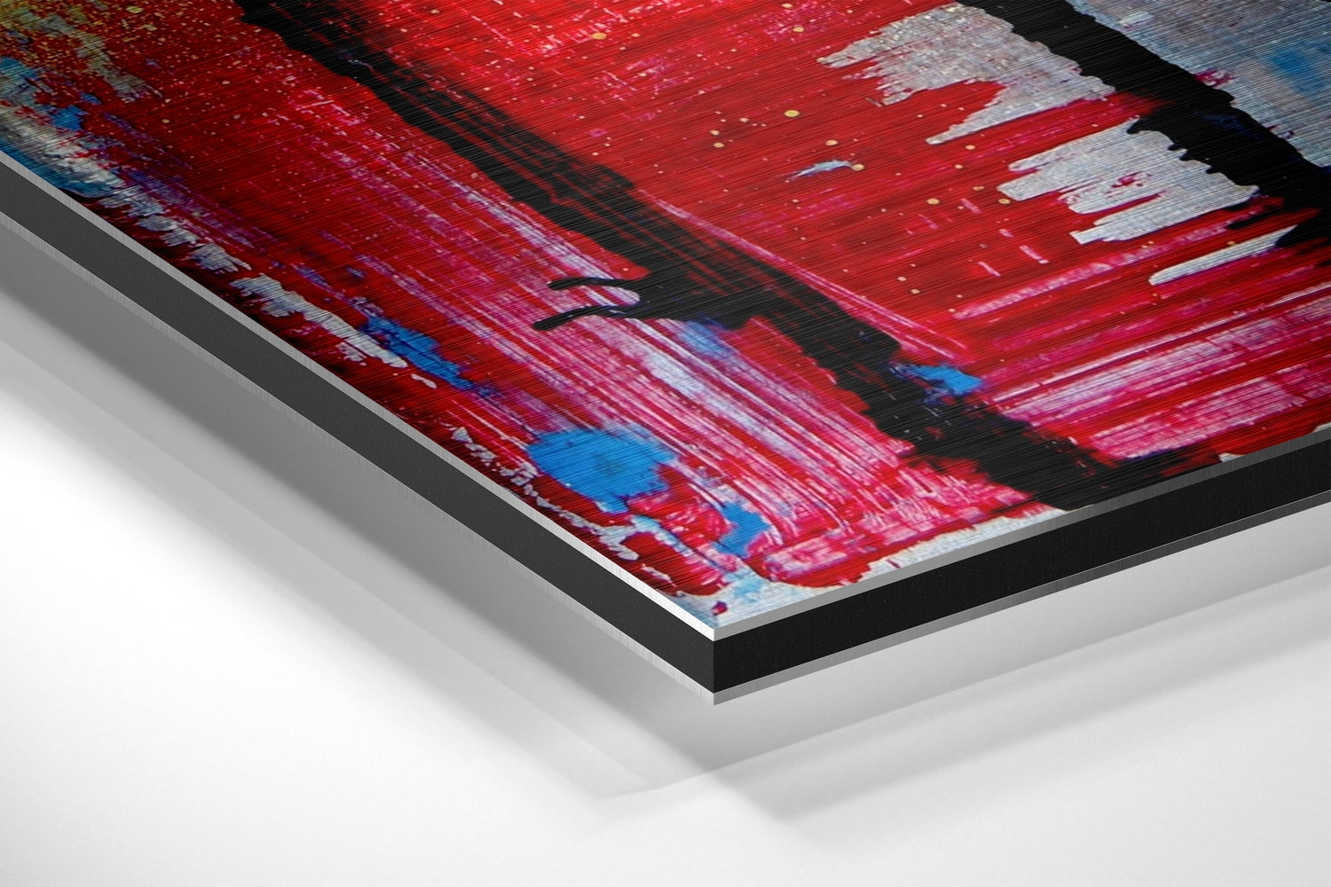 Angled perspective view of brushed aluminium Dibond wall art featuring red, pink, blue and black abstract brushstroke design with layered frame edges visible.