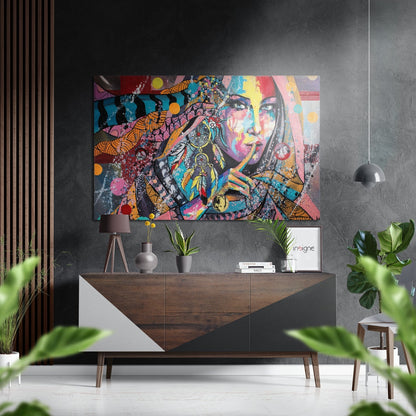 Colorful pop art portrait with vibrant geometric patterns displayed above a wooden console table in a modern interior setting.