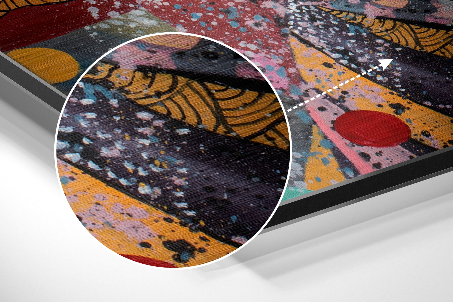 Close-up detail of brushed aluminium wall art showing textured surface with abstract patterns in black, yellow, pink, red, and blue paint splatters.
