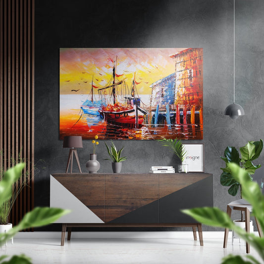 Colorful boat and harbor scene with golden sunset displayed above wooden dresser in modern gray interior with plants.