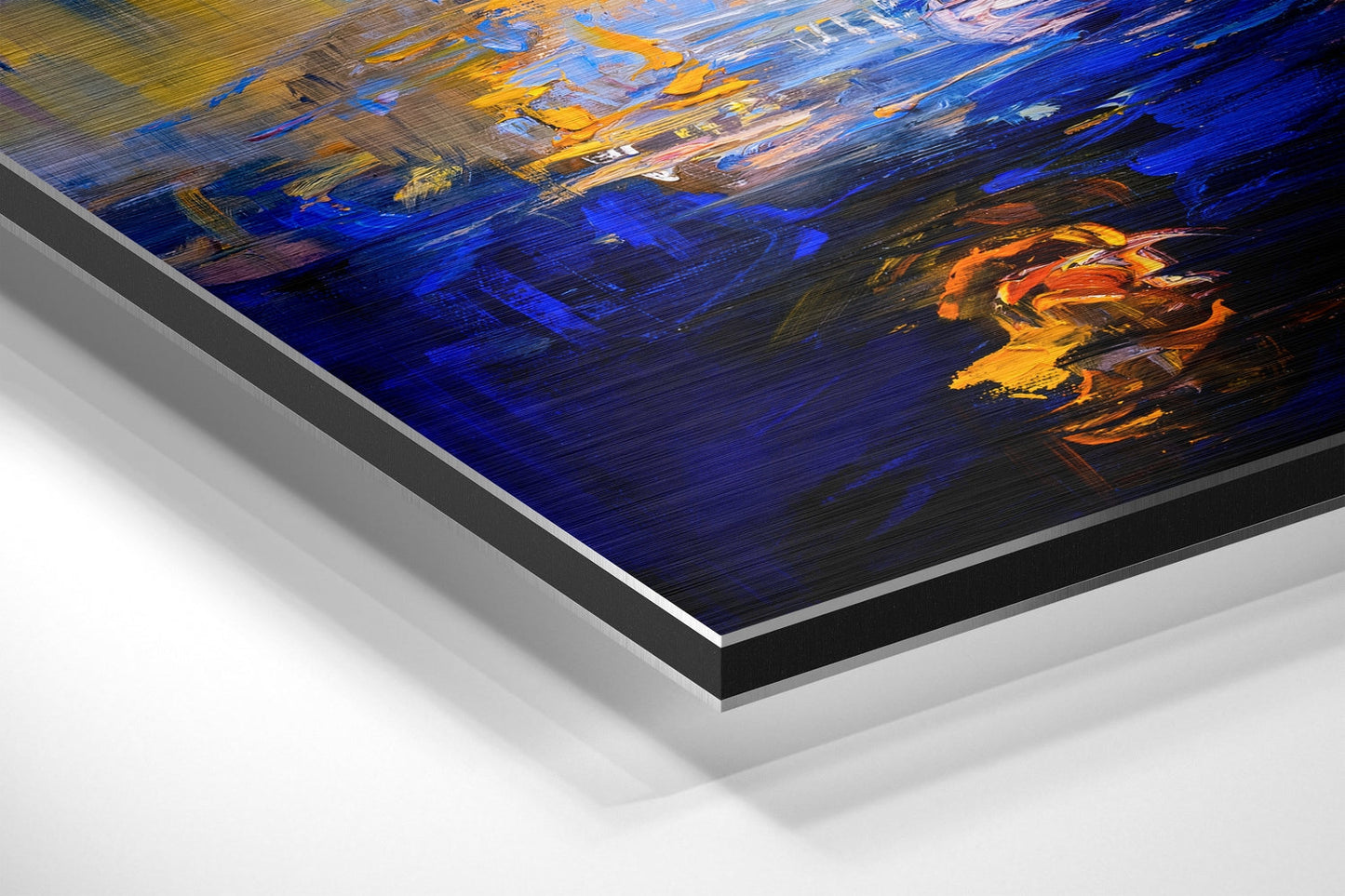 Angled corner view of brushed aluminum dibond panel displaying abstract painted sunset with deep blue, orange, and yellow brushstrokes.