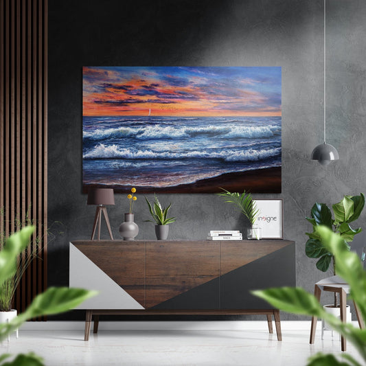 Coastal sunset seascape with orange sky and white-capped waves displayed on aluminum wall above wooden console in modern interior.