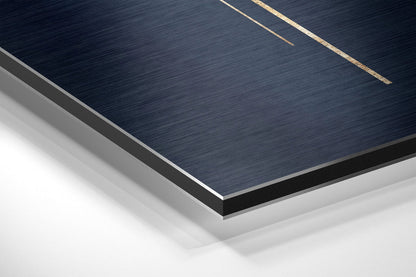 Close-up angled view of layered Dibond wall art showing dark brushed aluminum surface with gold accent lines and white backing layers.