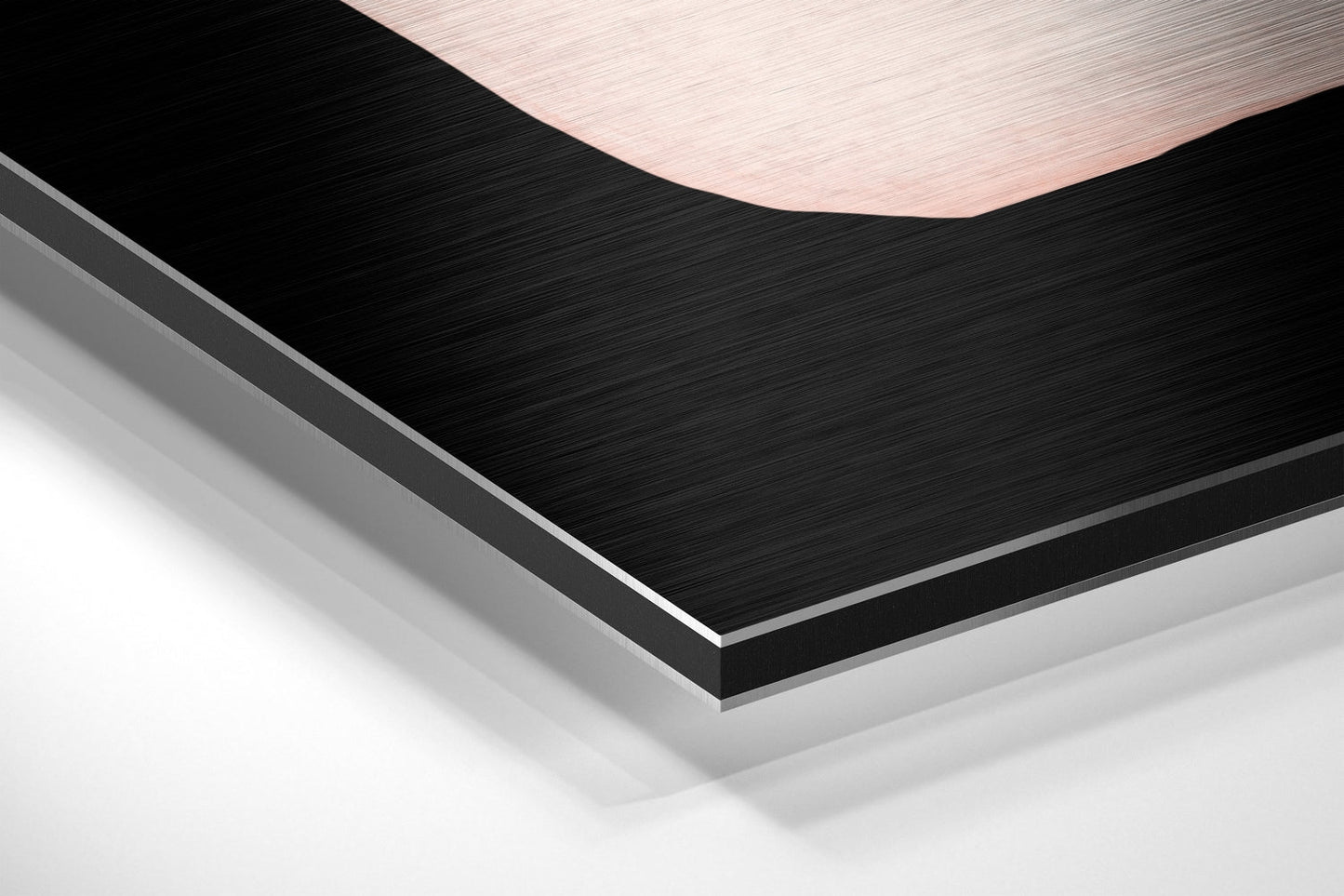 Angled close-up view of layered brushed aluminium Dibond wall art showing black and white textured surfaces with peach-toned top edge.