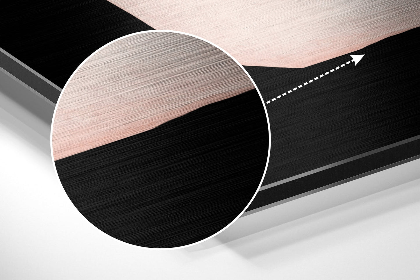 Close-up angled view of circular brushed aluminum wall art with horizontal black and rose gold striped pattern and white border.