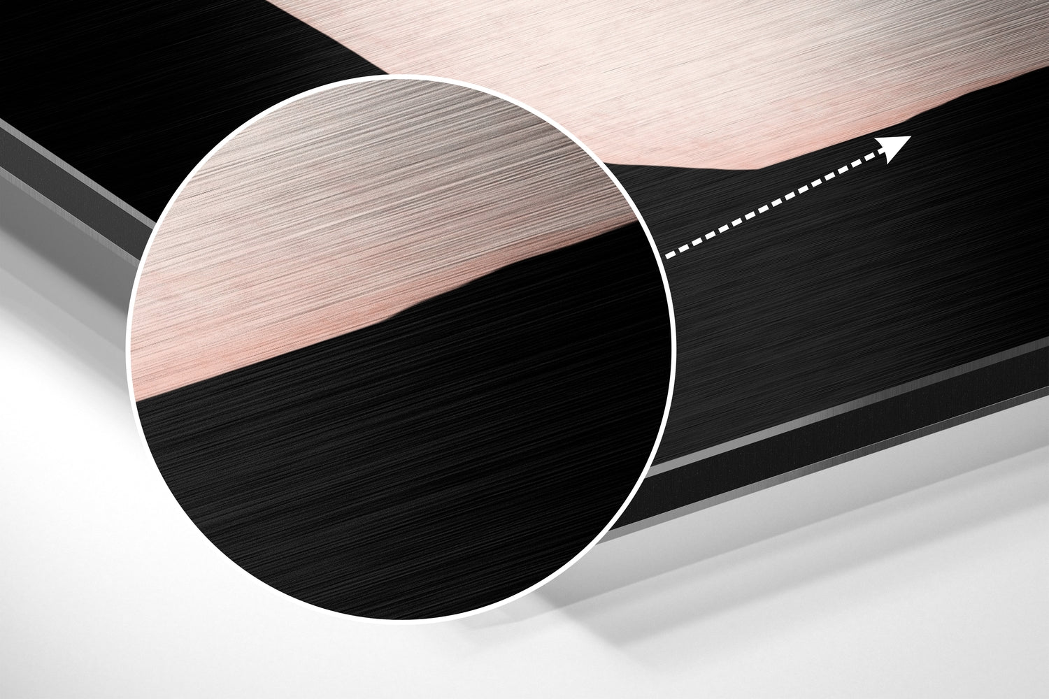 Close-up angled view of circular brushed aluminum wall art with horizontal black and rose gold striped pattern and white border.