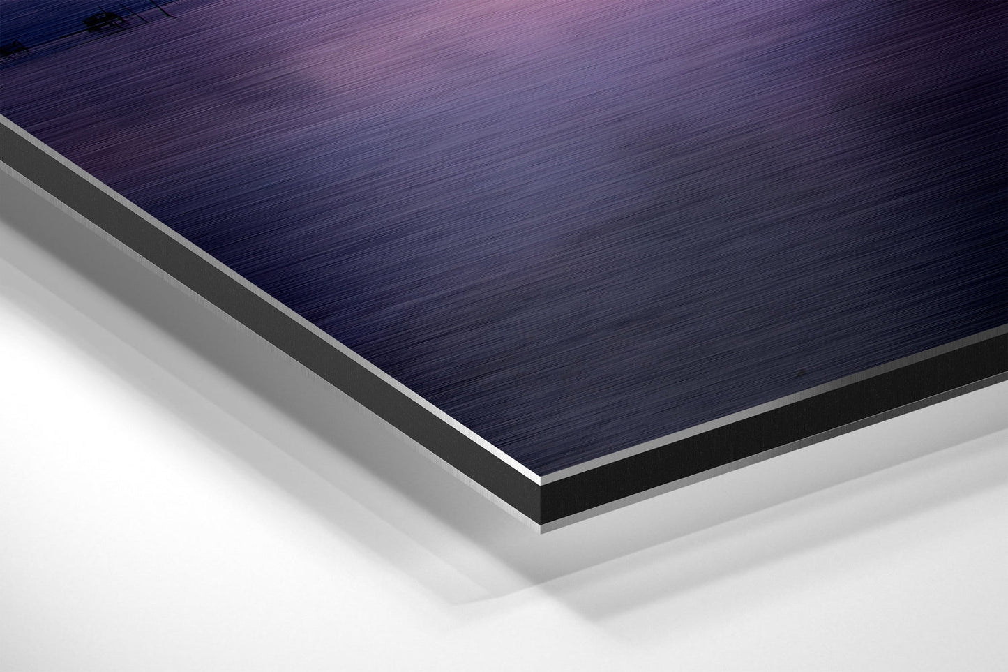 Close-up angled view of layered Dibond wall art showing brushed dark blue top surface with silver and white composite layers beneath.