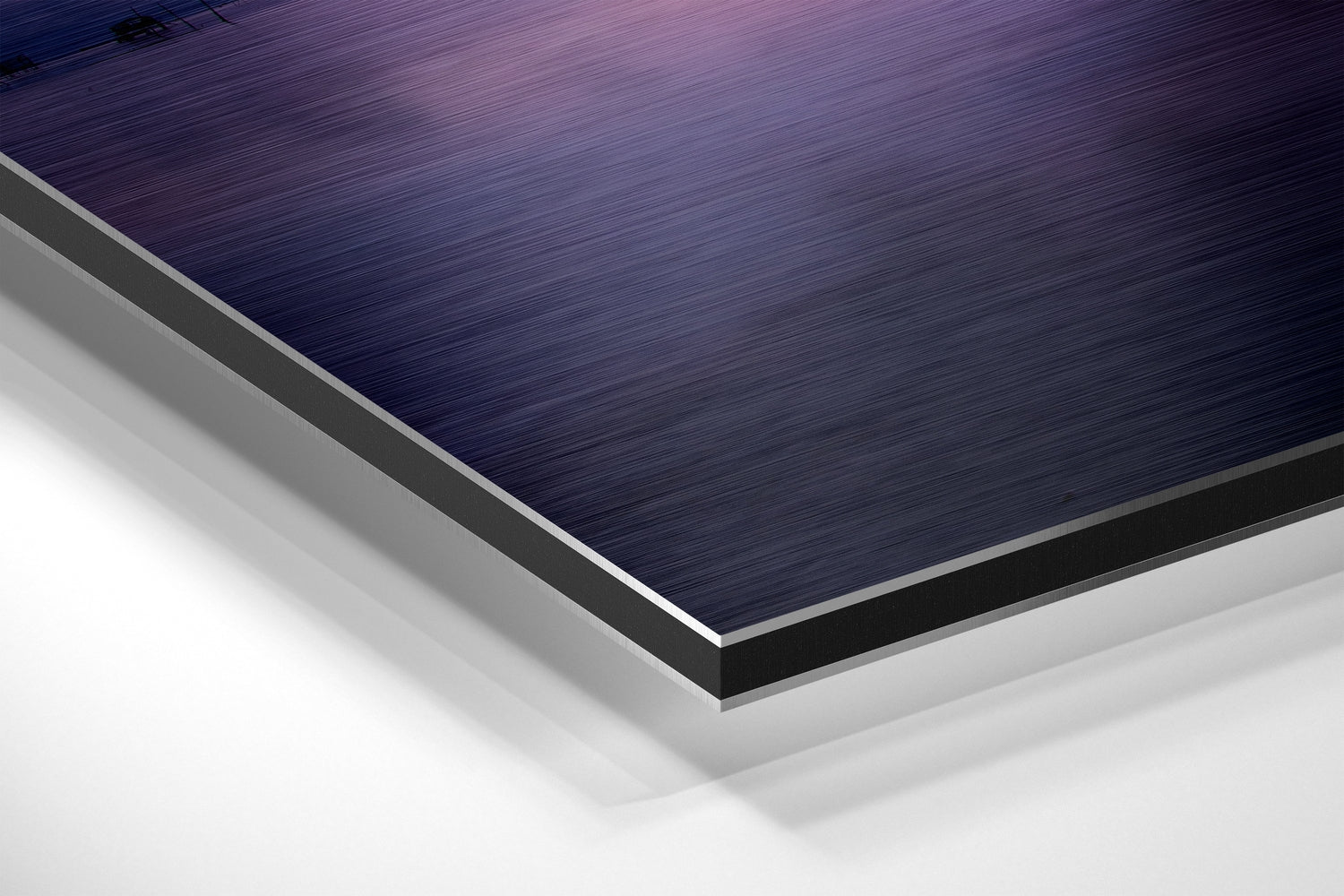 Close-up angled view of layered Dibond wall art showing brushed dark blue top surface with silver and white composite layers beneath.