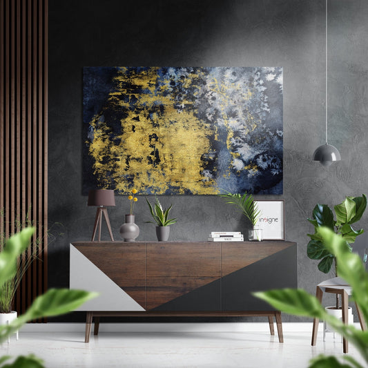 Abstract gold and navy blue brushed metal wall art displayed above a wooden console table in a modern interior setting.