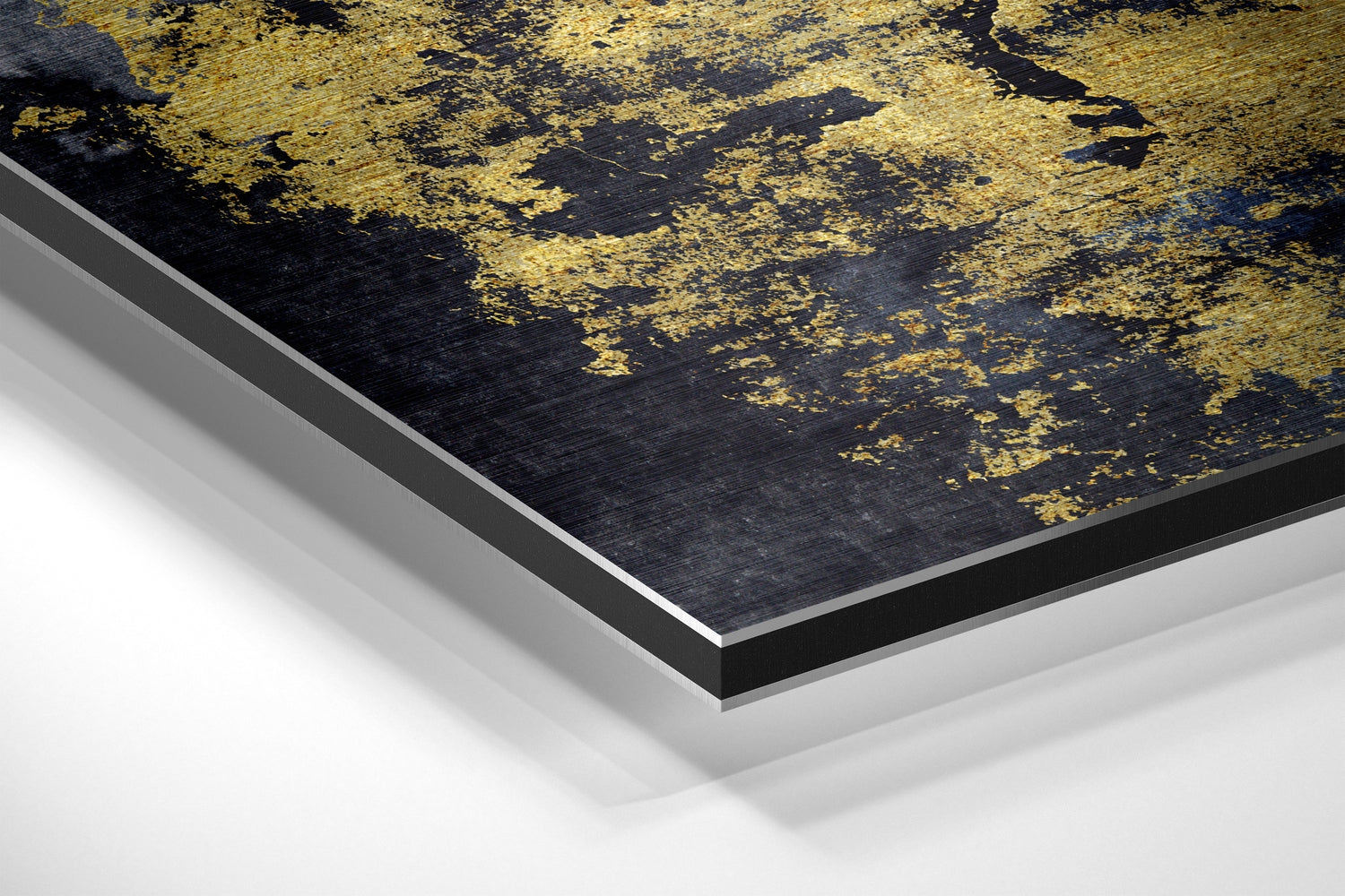 Angled close-up of black and gold brushed aluminium Dibond wall art showing layered edge construction and metallic finish detail.