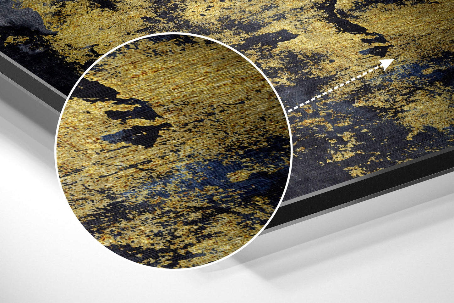 Close-up detail of gold brushed aluminum surface with black streaks and blue undertones, circled magnification view.