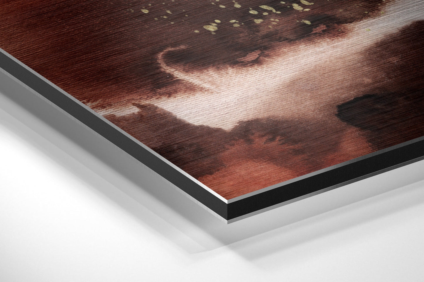 Close-up angled view of layered Dibond wall art showing brushed red and brown abstract design with white backing and black edge border.