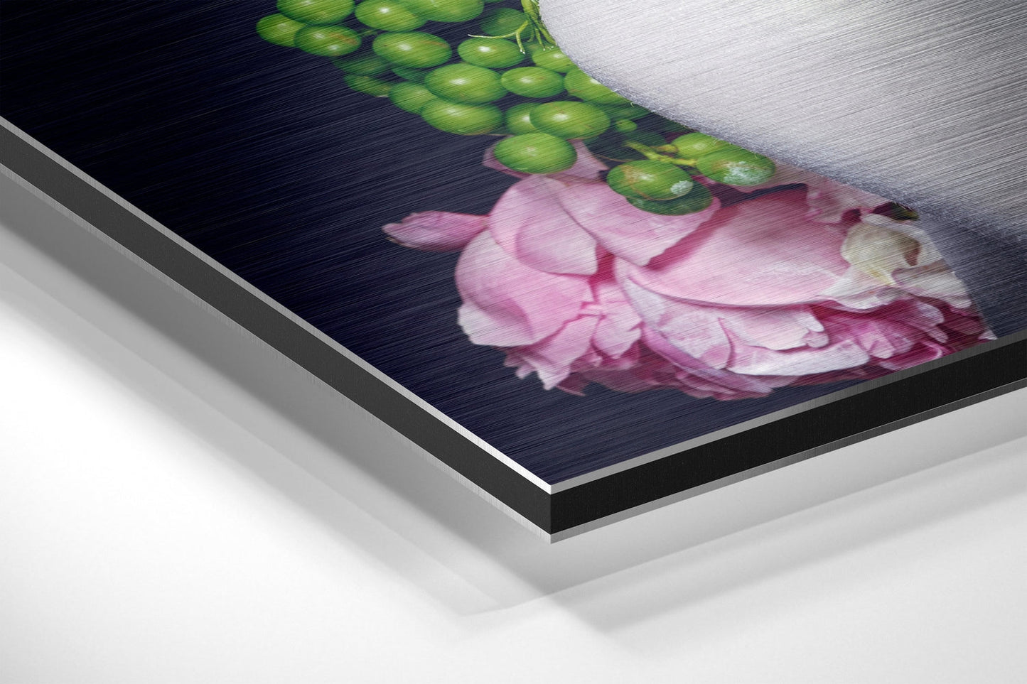 Close-up angled view of brushed aluminum wall art showing pink flowers and green hops against dark background.